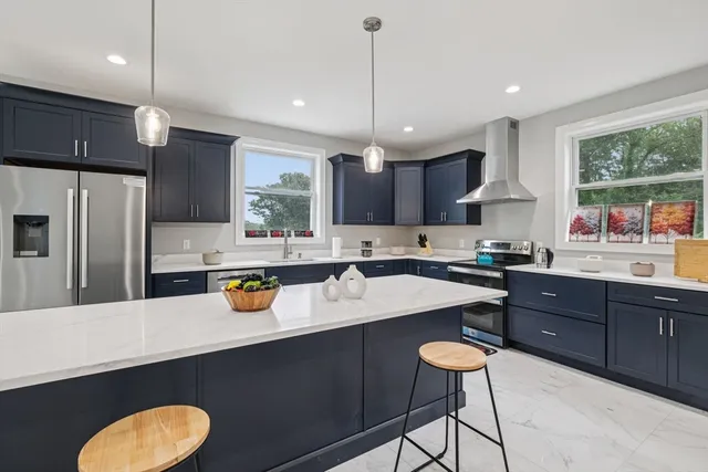 a kitchen with a sink a center island cabinets and stainless steel appliances