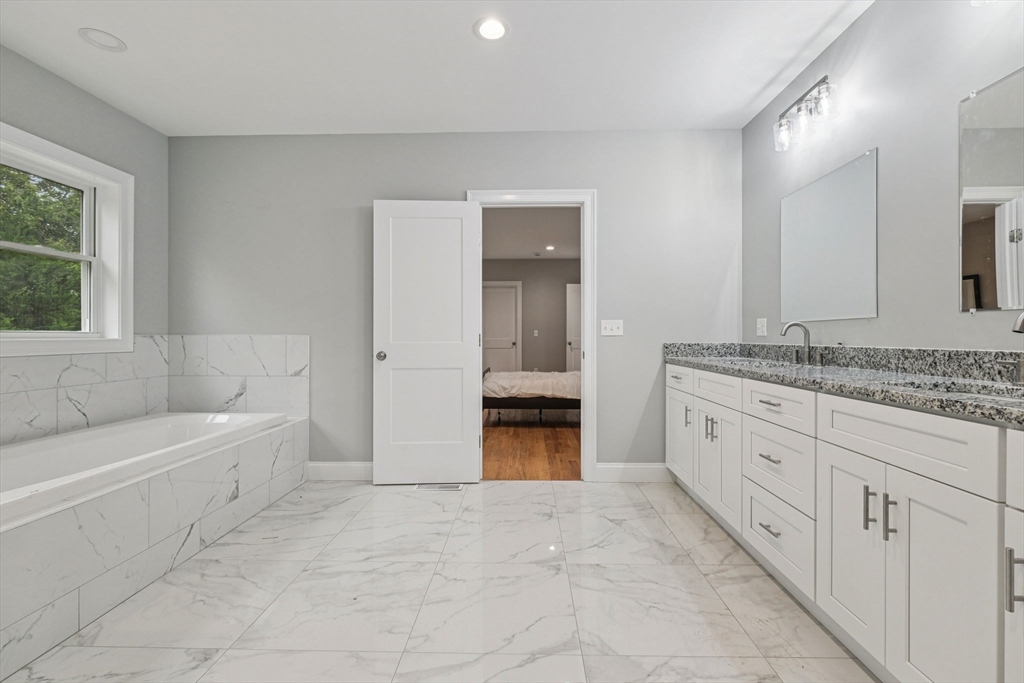 920 Drift Road Westport, MA 02790 - Photo 27 of 41 a bathroom with a granite countertop sink a mirror and a bathtub