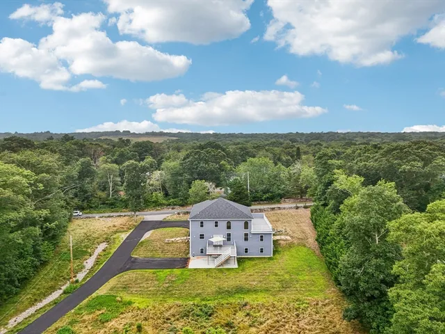 an aerial view of a house with a garden and trees