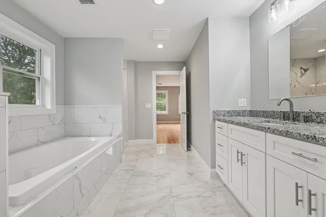 a spacious bathroom with sink shower and bathtub