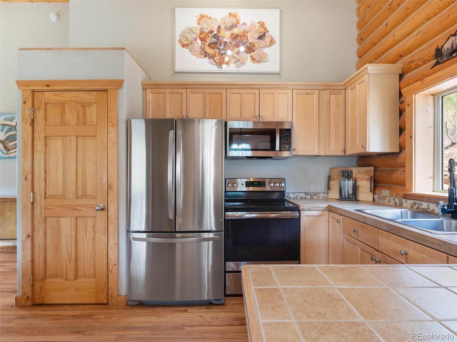 603 Old State Road Bailey, CO 80421 - Photo 13 of 40 a kitchen with stainless steel appliances granite countertop a refrigerator stove and sink