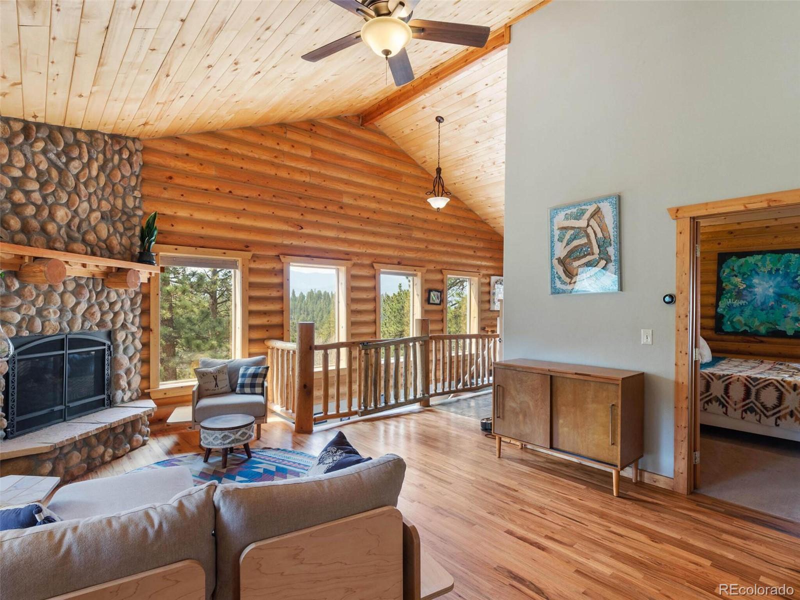 603 Old State Road Bailey, CO 80421 - Photo 17 of 40 a living room with furniture a fireplace and a flat screen tv