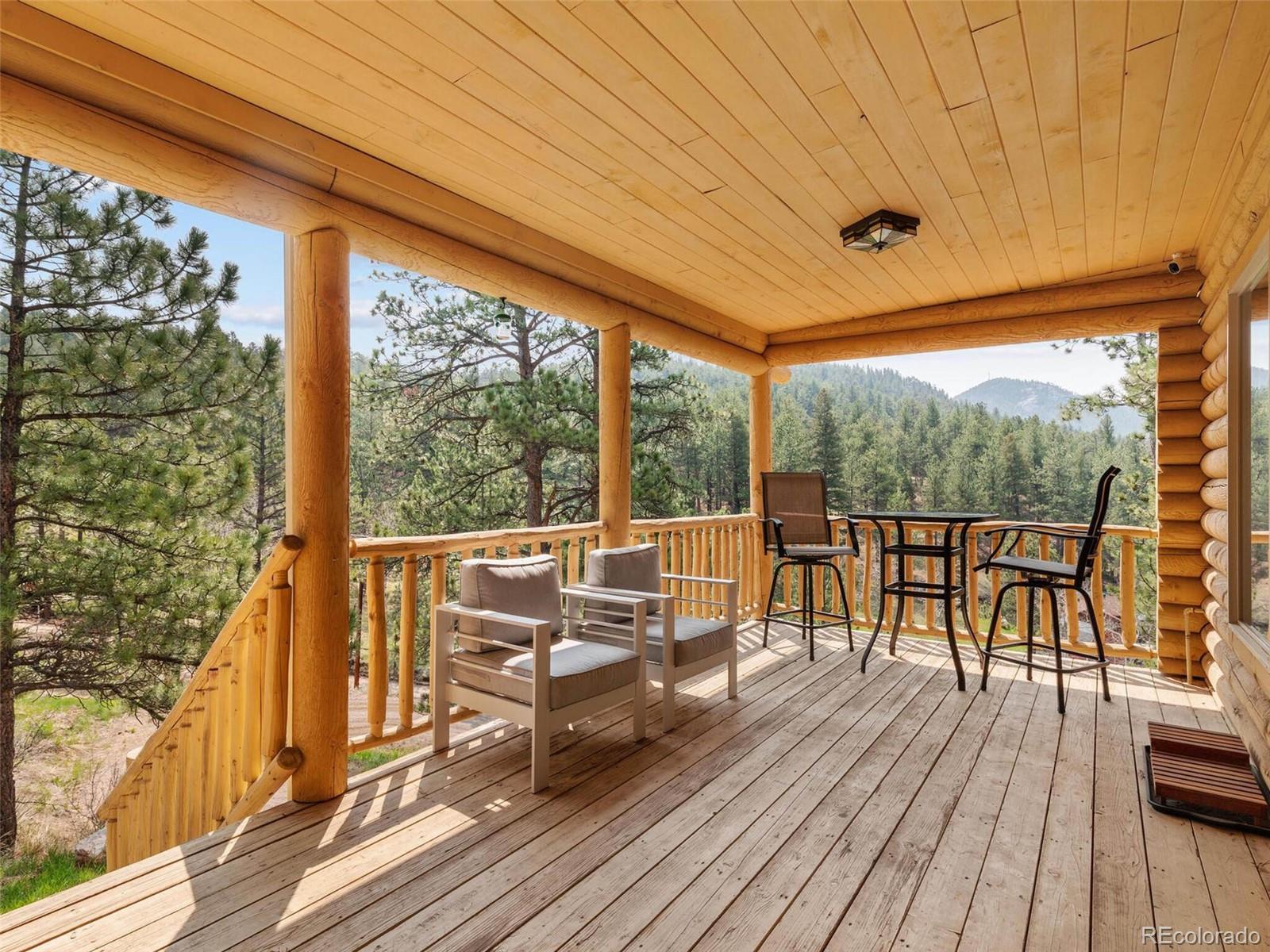603 Old State Road Bailey, CO 80421 - Photo 18 of 40 a view of a balcony with chairs and wooden floor