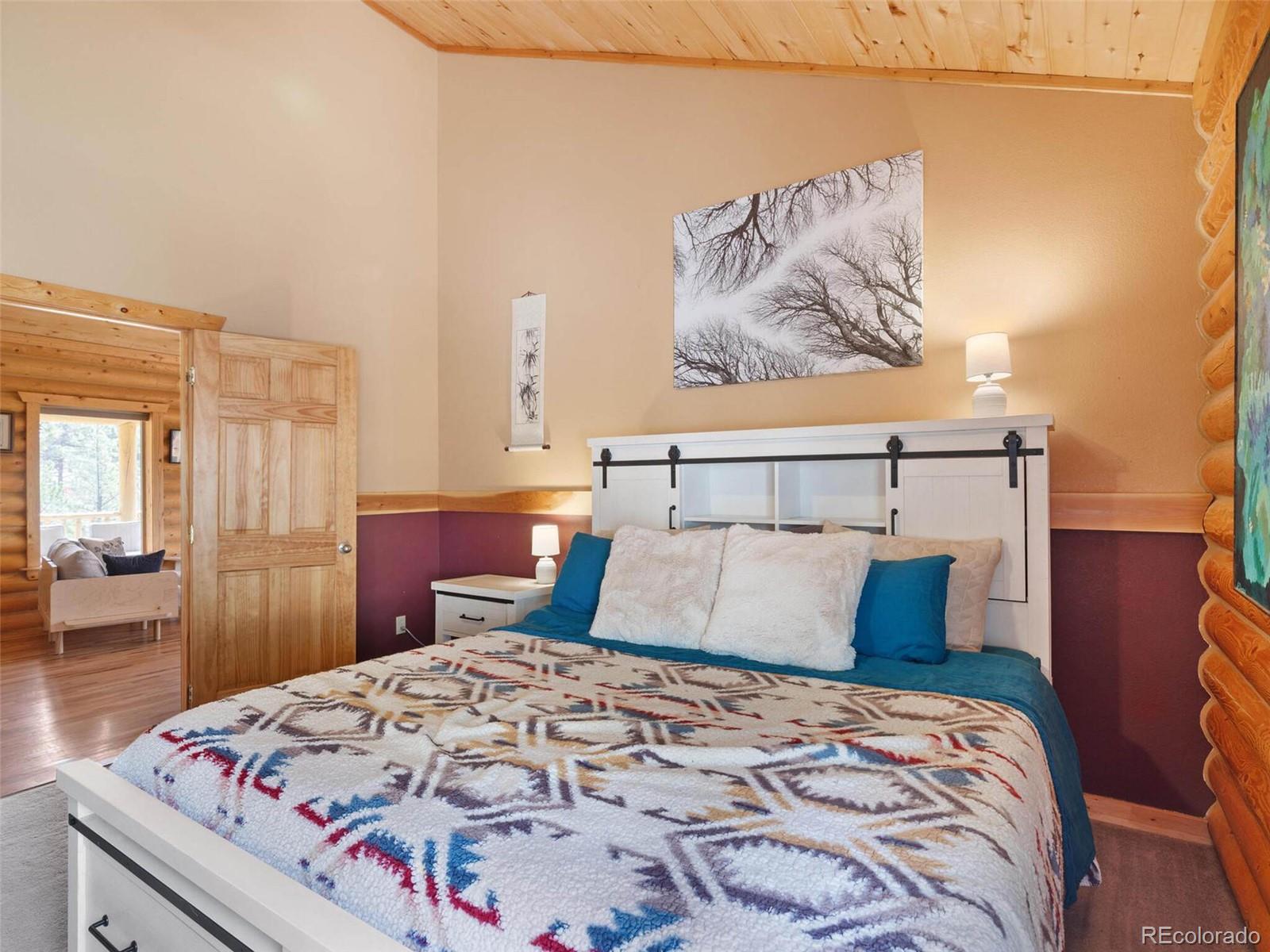 603 Old State Road Bailey, CO 80421 - Photo 22 of 40 a bedroom with a bed and wooden floor