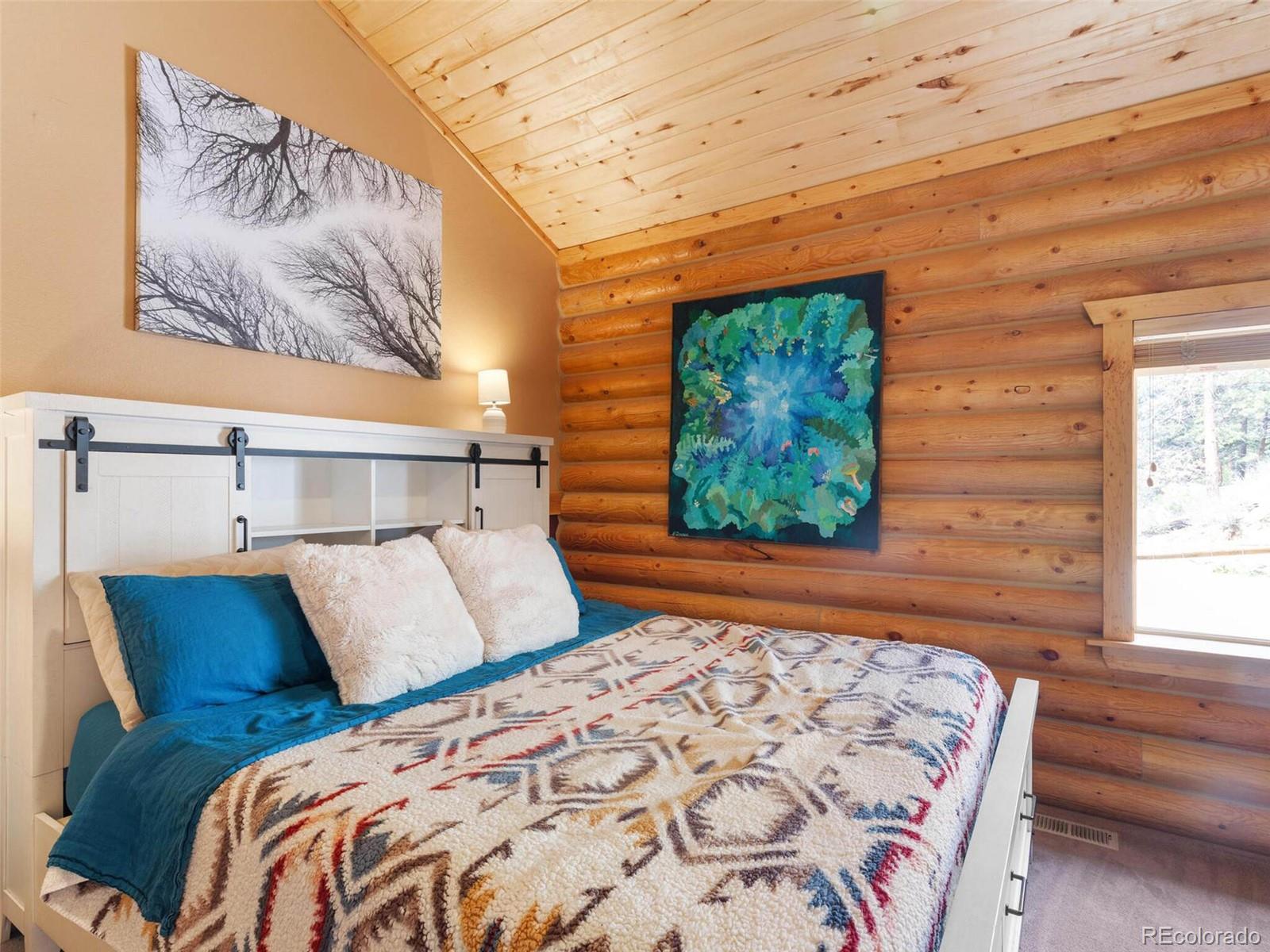 603 Old State Road Bailey, CO 80421 - Photo 23 of 40 a bed sitting in a bedroom next to a window