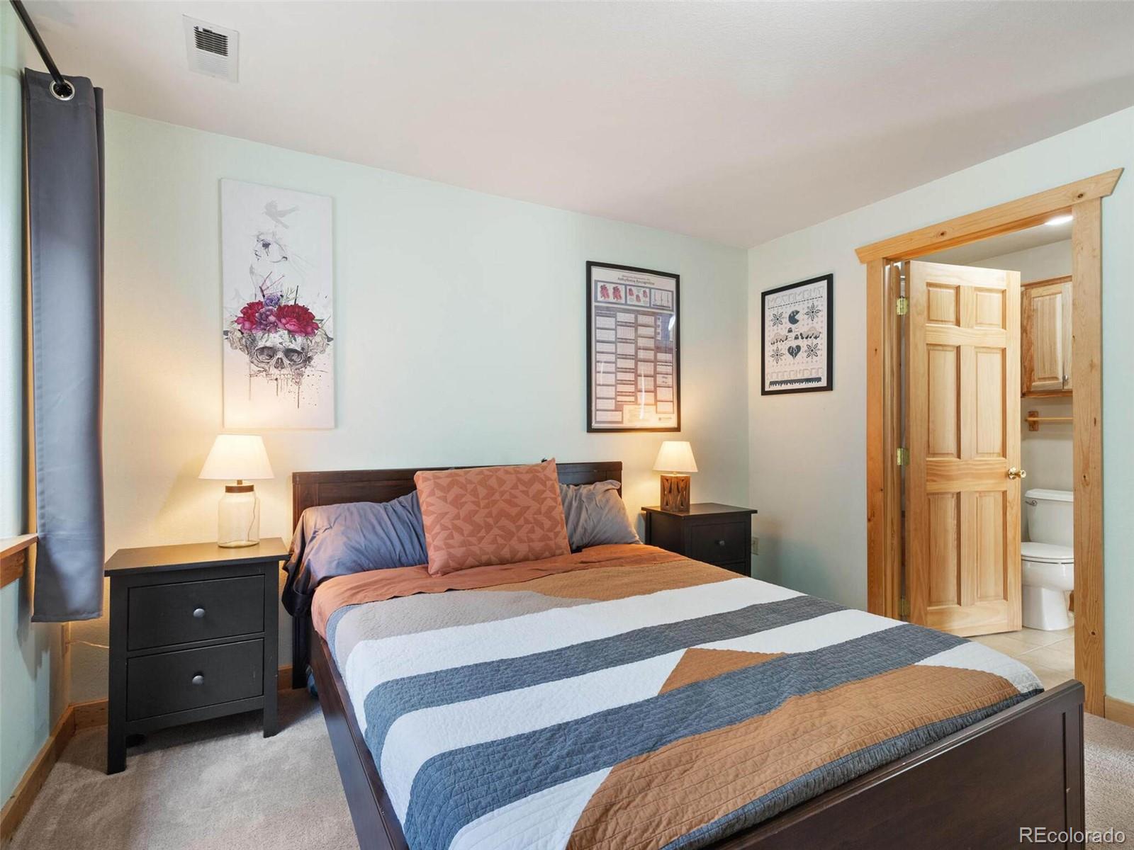 603 Old State Road Bailey, CO 80421 - Photo 35 of 40 a bedroom with a bed and a chandelier