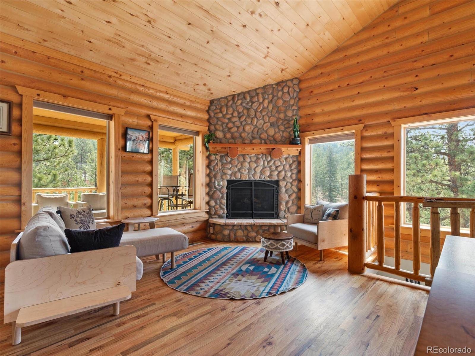 603 Old State Road Bailey, CO 80421 - Photo 9 of 40 a living room with furniture wooden floor and a fireplace