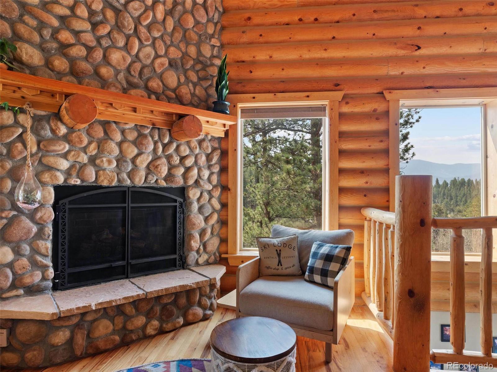 603 Old State Road Bailey, CO 80421 - Photo 10 of 40 a living room with furniture and a fireplace