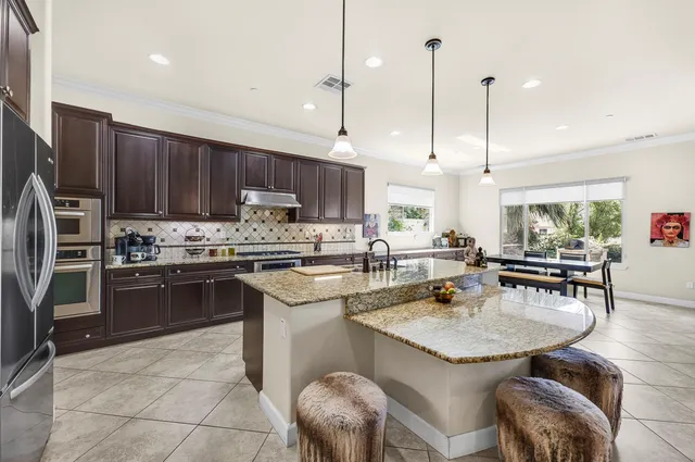 a spacious bedroom with a bed and a flat tv screen on dresser