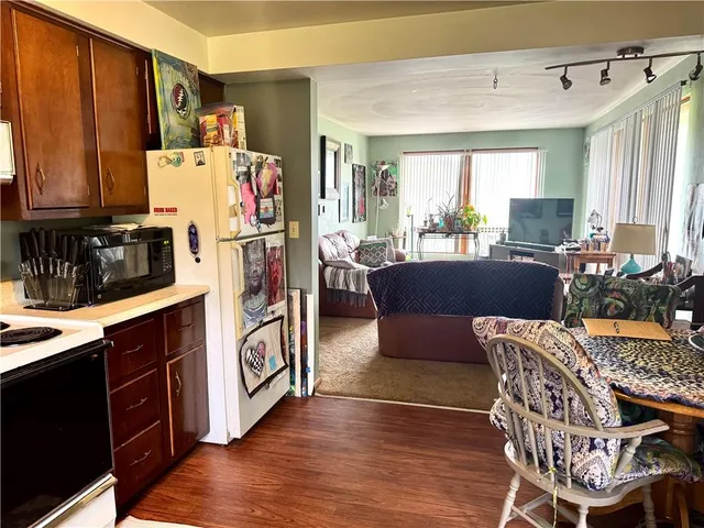 a work place with furniture a large window and wooden floor