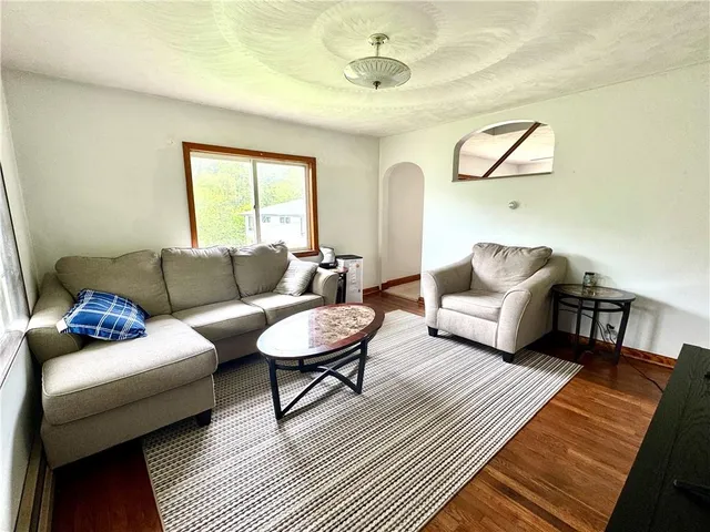 a living room with furniture a flat screen tv and a large window