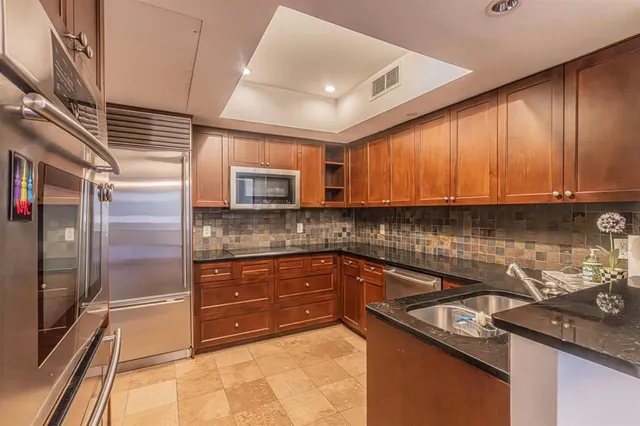 a kitchen with granite countertop stainless steel appliances sink microwave and cabinets