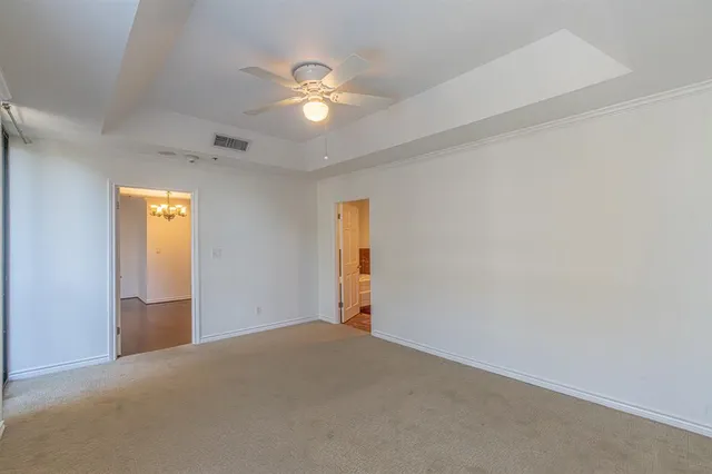 an empty room with a chandelier fan