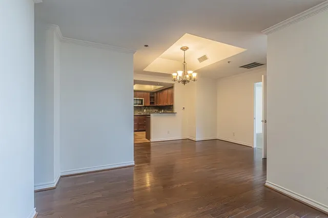a view of a livingroom with a chandelier fan and windows