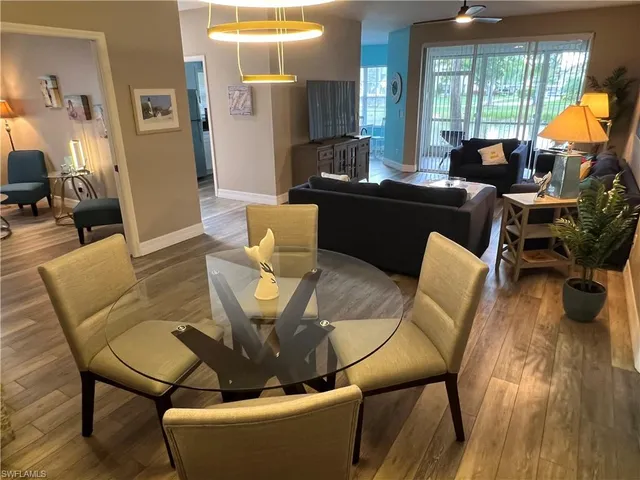 a living room with furniture a fireplace and large windows