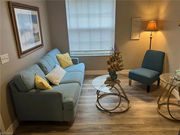 a living room with furniture a lamp and a window