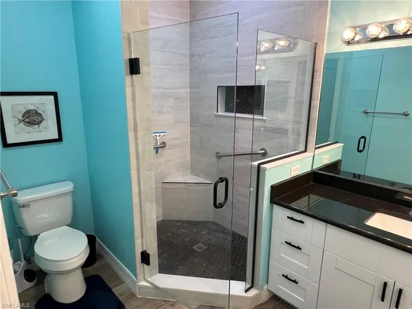 a bathroom with a granite countertop toilet and a sink