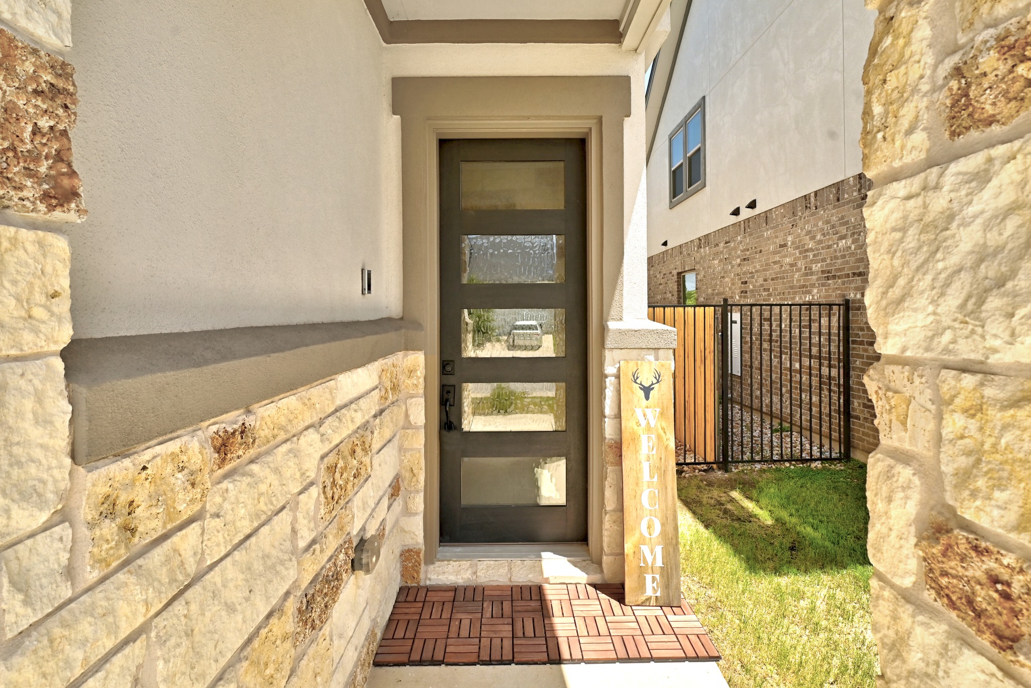 2702 Sebring Circle Austin, TX 78747 - Photo 4 of 35 Natural stone accents flank a modern glass-paneled front door to welcome you inside.