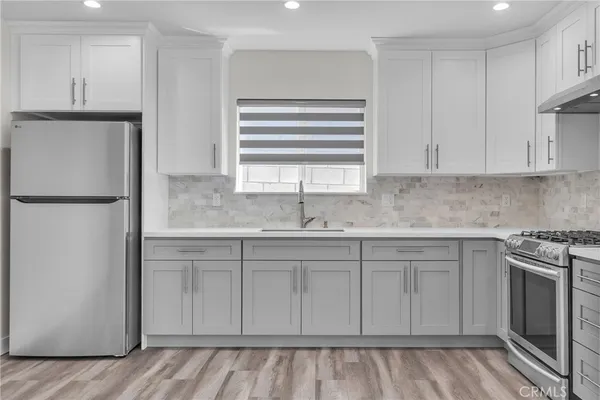 a kitchen with stainless steel appliances granite countertop a refrigerator sink and cabinets