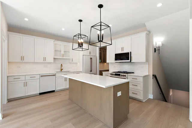 a kitchen with stainless steel appliances granite countertop a stove top oven a sink dishwasher and a refrigerator