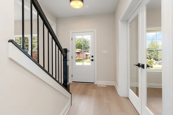 a view of a hallway with wooden floor and stairs
