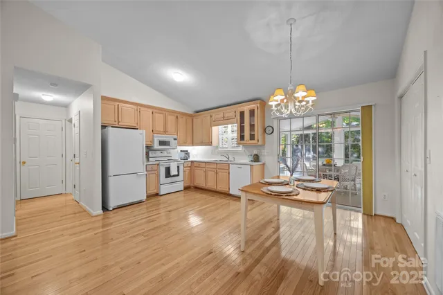 a dining room with furniture a chandelier and wooden floor