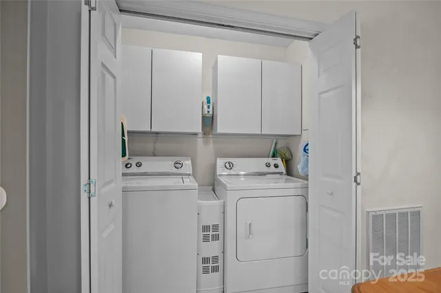 a spacious bedroom with a bed chandelier and a window