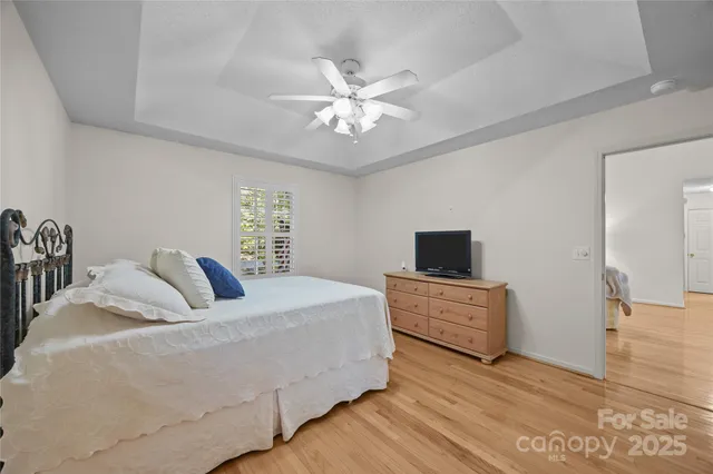 a bedroom with a large bed and a flat tv screen on dresser
