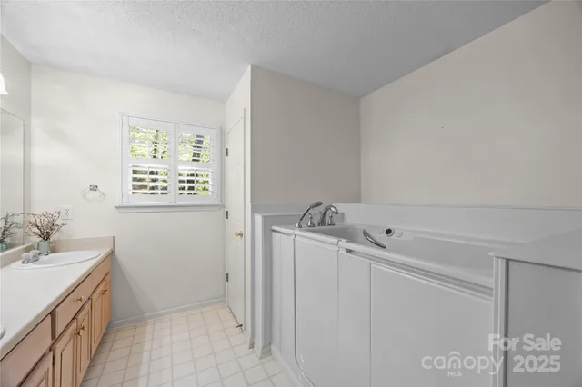 a bathroom with a granite countertop sink a mirror and a shower