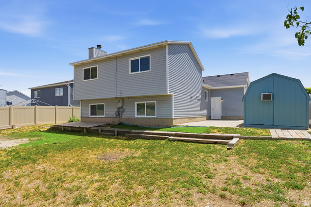 7910 Woolley Way Magna, UT 84044 - Photo 22 of 26 Rear exterior featuring gray siding and white trim