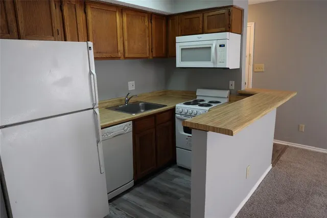 a kitchen with stainless steel appliances granite countertop a refrigerator a stove a sink and a microwave