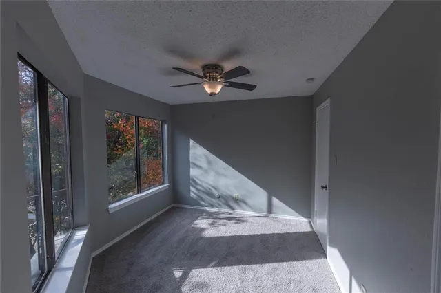 a view of livingroom with window ceiling fan and a bathroom