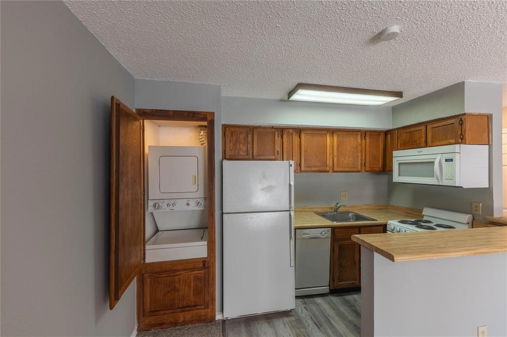 9805 Walnut Street, Unit 305C Dallas, TX 75243 - Photo 7 of 19 a kitchen with a refrigerator and a stove top oven