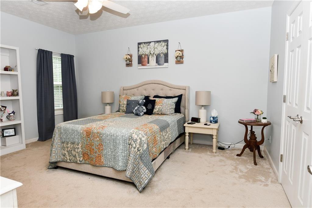 795 Sunset Ridge Lane Southeast Lawrenceville, GA 30045 - Photo 5 of 47 a bedroom with a bed and a chandelier