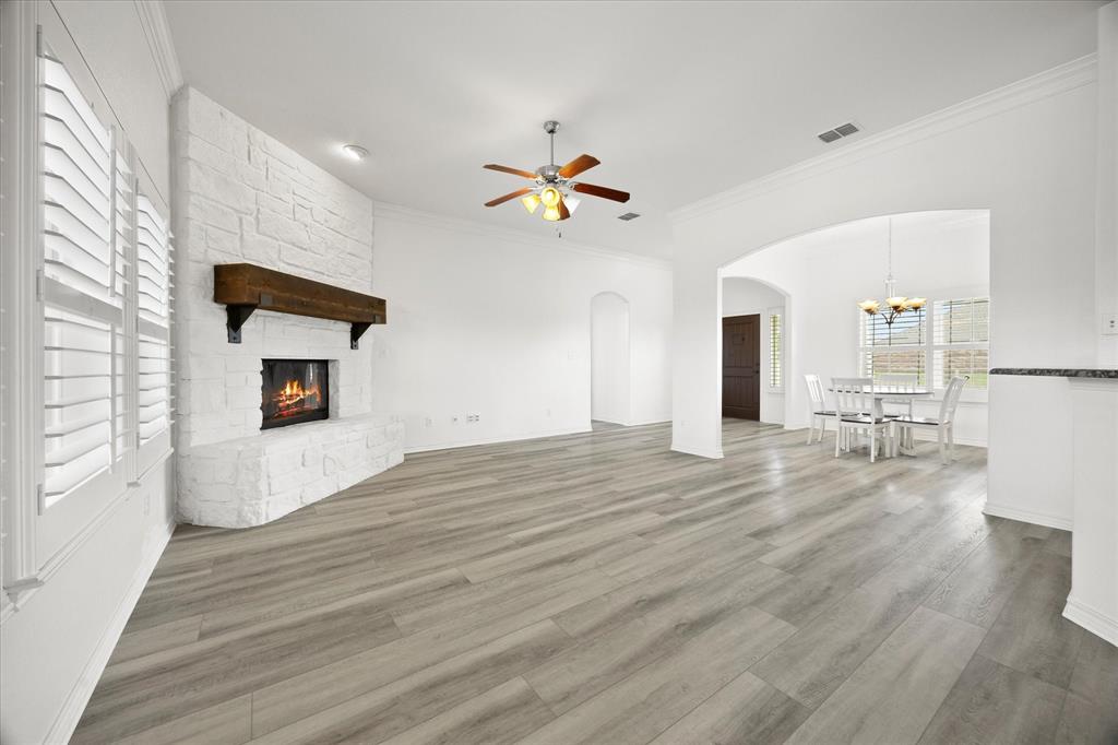 528 Hubbard Circle Nevada, TX 75173 - Photo 11 of 38 a view of a livingroom with a fireplace a chandelier fan and wooden floor