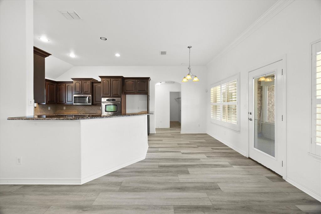 528 Hubbard Circle Nevada, TX 75173 - Photo 12 of 38 a view of kitchen with refrigerator microwave and wooden floor