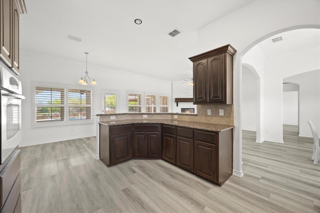 528 Hubbard Circle Nevada, TX 75173 - Photo 15 of 38 a large kitchen with kitchen island wooden floors and stainless steel appliances