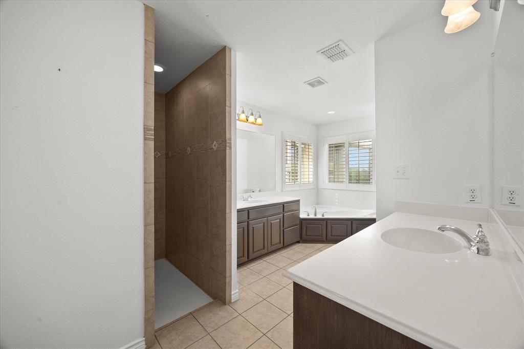 528 Hubbard Circle Nevada, TX 75173 - Photo 19 of 38 a spacious bathroom with a sink vanity and a mirror