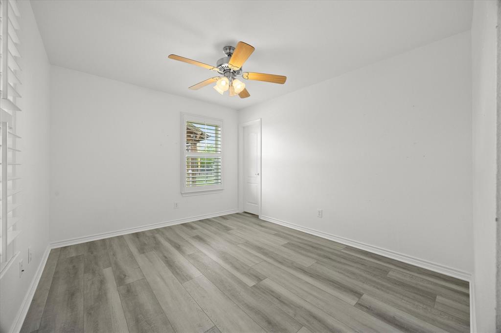 528 Hubbard Circle Nevada, TX 75173 - Photo 24 of 38 an empty room with wooden floor fan and windows