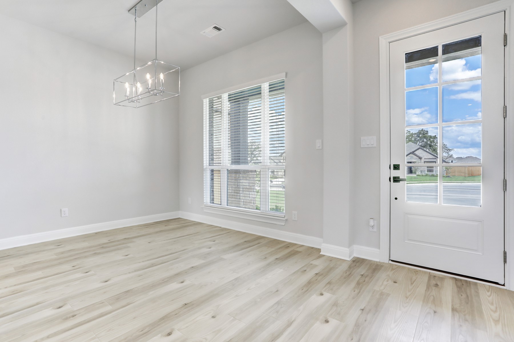 118 Periwinkle Lane Bastrop, TX 78602 - Photo 2 of 15 an empty room with wooden floor cabinet and windows