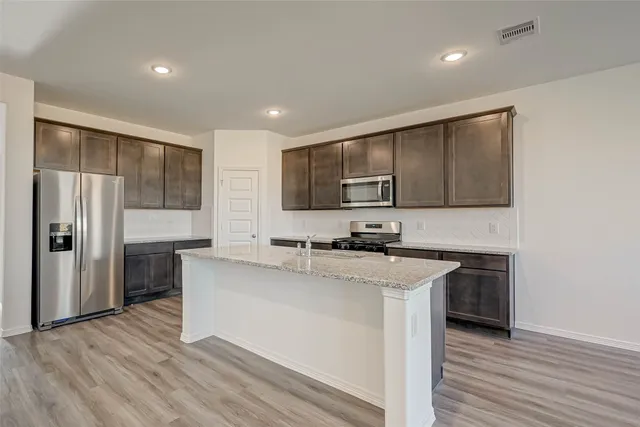 a kitchen with stainless steel appliances a sink stove and refrigerator