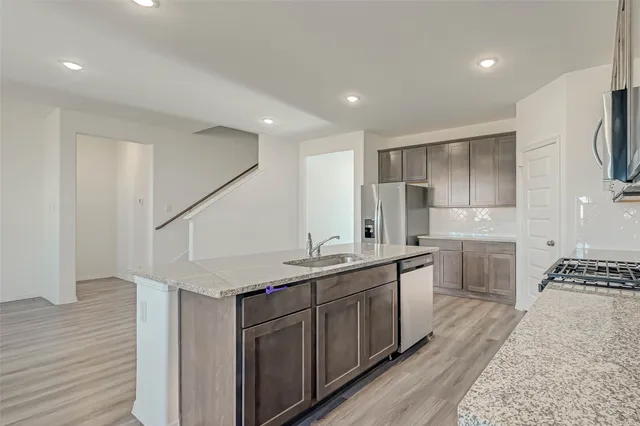 a kitchen with a sink stove and cabinets