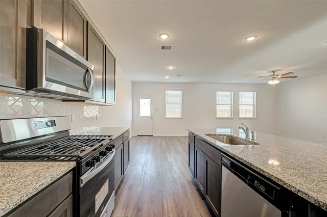 a kitchen with granite countertop stainless steel appliances and wooden cabinets