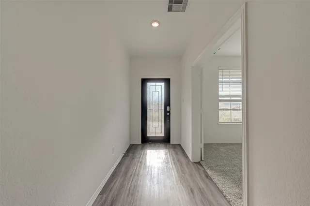 a view of hallway with wooden floor
