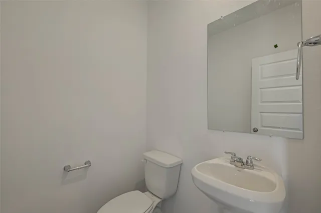 a bathroom with a toilet a sink and mirror