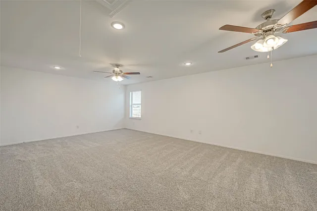 an empty room with fan and windows