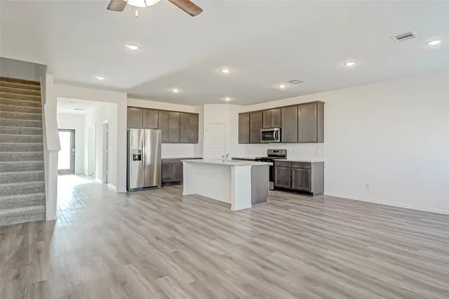 a large kitchen with stainless steel appliances granite countertop a large counter top and a sink