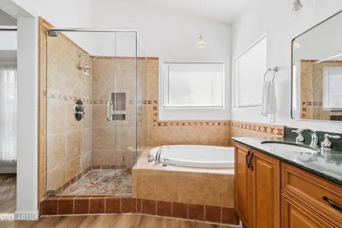 a bathroom with a granite countertop sink a mirror a shower and a bathtub