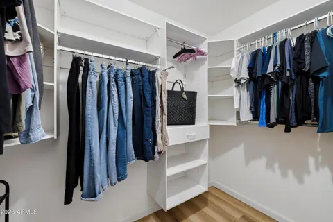 a view of walk in closet with clothes and shoes