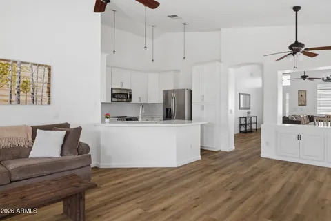 a living room with stainless steel appliances kitchen island a table and chairs
